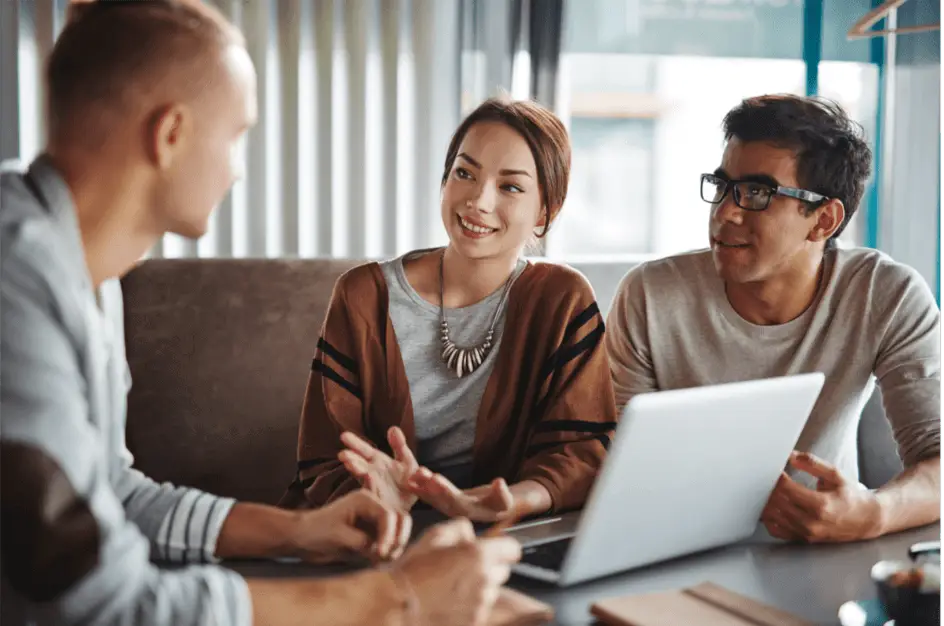 Salesman explaining the benefits of ATTYX HVAC services to potential customers in their home.